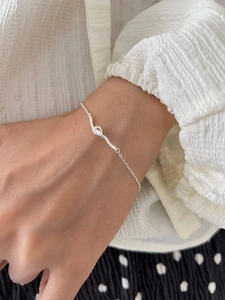 Close-up of S925 sterling silver woven knot bracelet worn on a woman's wrist
