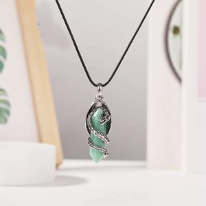 Détail d'un pendentif en pierre hexagonale verte avec dragon argenté sur cordon