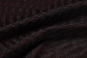 Macro view of burgundy and black knit fabric with breathable micro-mesh texture and soft drape