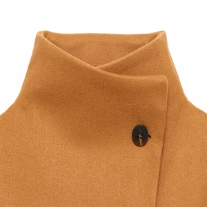 Detail of camel wool jacket showing high collar design and amber textured button closure