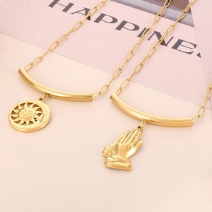 Vue détaillée de colliers trombone dorés avec pendentifs soleil lune et main de prière