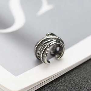 Vintage silver feather ear cuff with intricate carved texture and minimalist open design