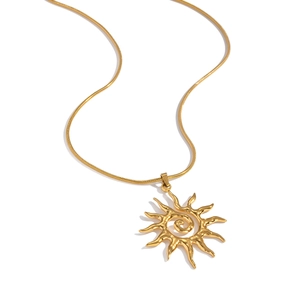 Detail of a golden sun pendant necklace with sleek snake chain and metallic texture