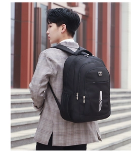 Outdoor shot showing a large black travel backpack worn by a model in a city setting