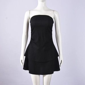 Close-up of black strapless mini dress featuring textured pleated fabric and layered ruffles