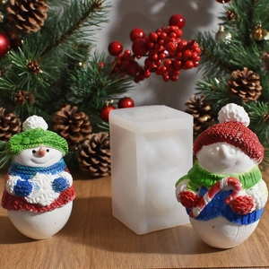 Macro view of 3D snowman silicone mold with finished Christmas candles on wood surface