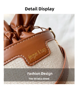 Detail of the brown leather stitching and beige woven fabric on this bucket bag