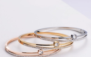 Macro shot of three-tone interlocking bangles with pavé crystals and bezel-set center stones