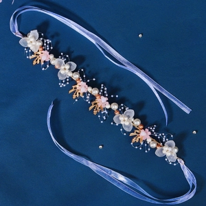 Detail of bridal headband with gold leaves, faux pearls and crystal flowers on blue ribbon