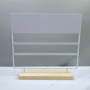 Detail of 144-hole white metal earring organizer with a detachable wooden base