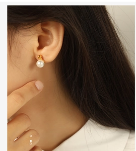 Detailed view of an elegant pearl stud earring worn on a female model for a chic look