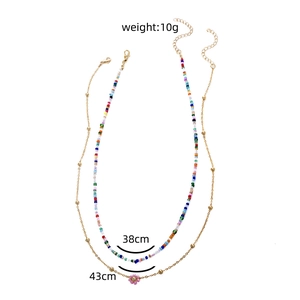 Collier double couche de perles colorées marguerite avec chaîne dorée et fleur rose