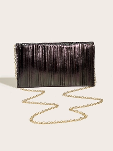 Macro view of metallic pleated evening clutch bag with gold chain strap in dark purple