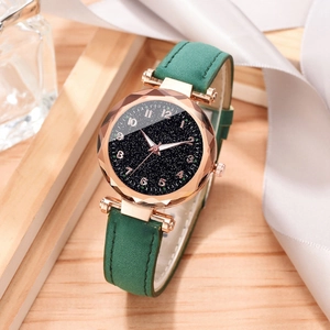 Close-up of starry dial watch with green leather strap and faceted glass detail