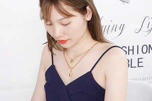 Detailed shot of a layered gold stainless steel necklace with heart and lock charms