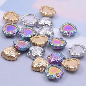 Gros plan de divers pendentifs en forme de cœur dorés et argentés pour bijoux DIY sur fond mauve