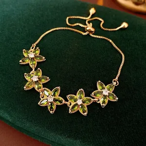 Elegant gold-plated adjustable bracelet featuring five green zircon flower charms on velvet