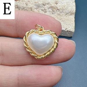 Close-up of heart pendant with white faux pearl and golden twisted rope border