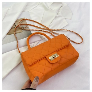 Detailed view of orange quilted PU leather bag with gold chain and diamond stitching