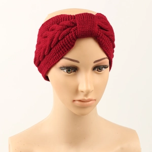 Close-up of red cable knit headband with warm lining and bow detail on model head