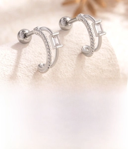 Detail of silver double-layered ear studs with clear zircon and surgical steel screw back