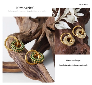 Detailed view of geometric gold earrings with green and clear pavé zircon stones