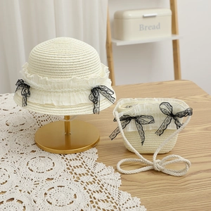 Détail de l'ensemble chapeau de paille et sac beige avec dentelle et nœuds noirs