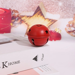 Vue macro d'une cloche de Noël en métal rouge de 5cm avec étoiles sur des livres