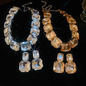 Detailed close-up of luxury square-cut gemstone jewelry sets in silver and gold finishes