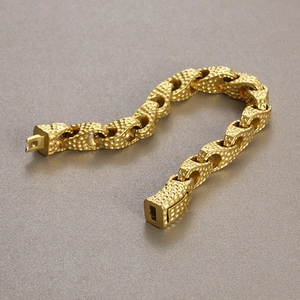 Macro shot of 18k gold plated hammered texture chain links on heavy duty men's bracelet