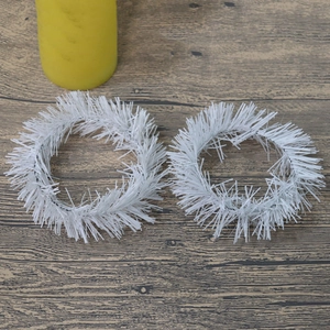 White tinsel Christmas candle ring wreaths on a rustic wooden texture surface