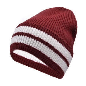 Close-up of burgundy ribbed knit beanie featuring thick white stripes and thick wool texture