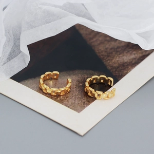 Detail view of gold-colored chain style 925 silver ear cuffs on a professional card