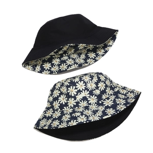 Reversible bucket hat featuring floral daisy print and solid black sun protection design