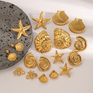 Golden stainless steel starfish and seashell earring set on natural grey rock