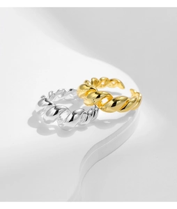 Close-up of gold and silver liquid metal twist rings on minimalist display