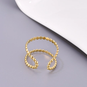 Adjustable gold beaded hollow ring in stainless steel displayed on a white plate