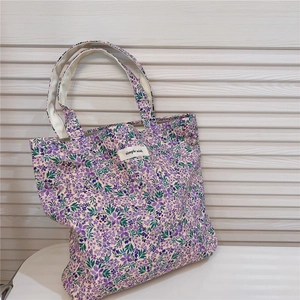 Detailed shot of purple floral tote bag with simple wish label and reinforced handles