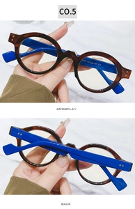 Detail view of tortoiseshell and blue eyeglass frames with specifications engraved on temples