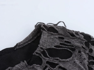 Détail de l'épaule en maille grise déchirée avec doublure noire de style punk et urbain