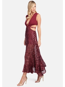 Détail d'une robe bordeaux à paillettes avec décolleté en V profond et découpes à la taille