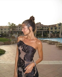 Detail of elegant black velvet floral texture and one-shoulder rose decoration