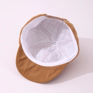 Detailed interior of brown corduroy baby hat with white quilted lining and soft sweatband