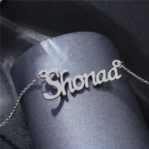 Collier avec pendentif prénom Shonaa en acier inoxydable poli sur fond gris texturé