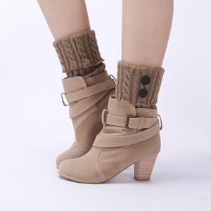 Close-up of beige suede ankle boots with high chunky heels and buttoned knit leg warmers