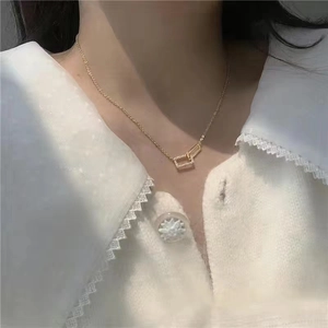 Detail of interlocking gold double rectangle pendants with pavé set crystals on an O-chain