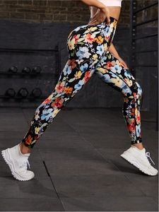 Close-up of high-waist yoga leggings with colorful floral print on black fabric