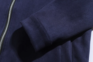Close-up of the smooth navy blue faux suede fabric and silver metal zipper detail