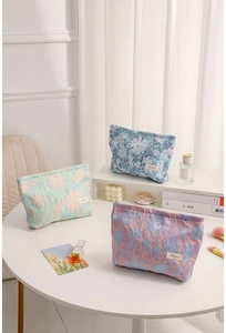Tre borse cosmetiche in jacquard floreale nei colori blu, verde e rosa pastello