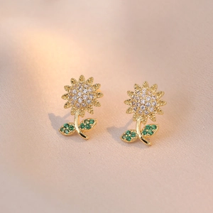 Golden sunflower earrings with white cubic zirconia and green leaf crystals on beige silk